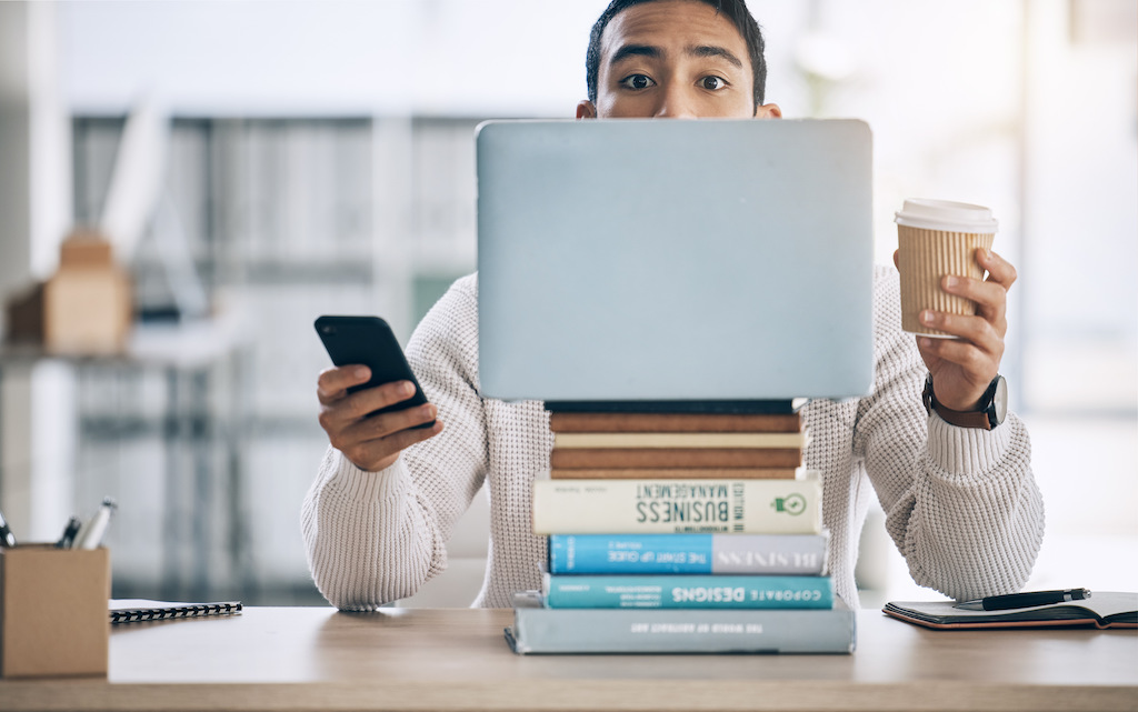 Business man feeling overwhelmed by a pile of work