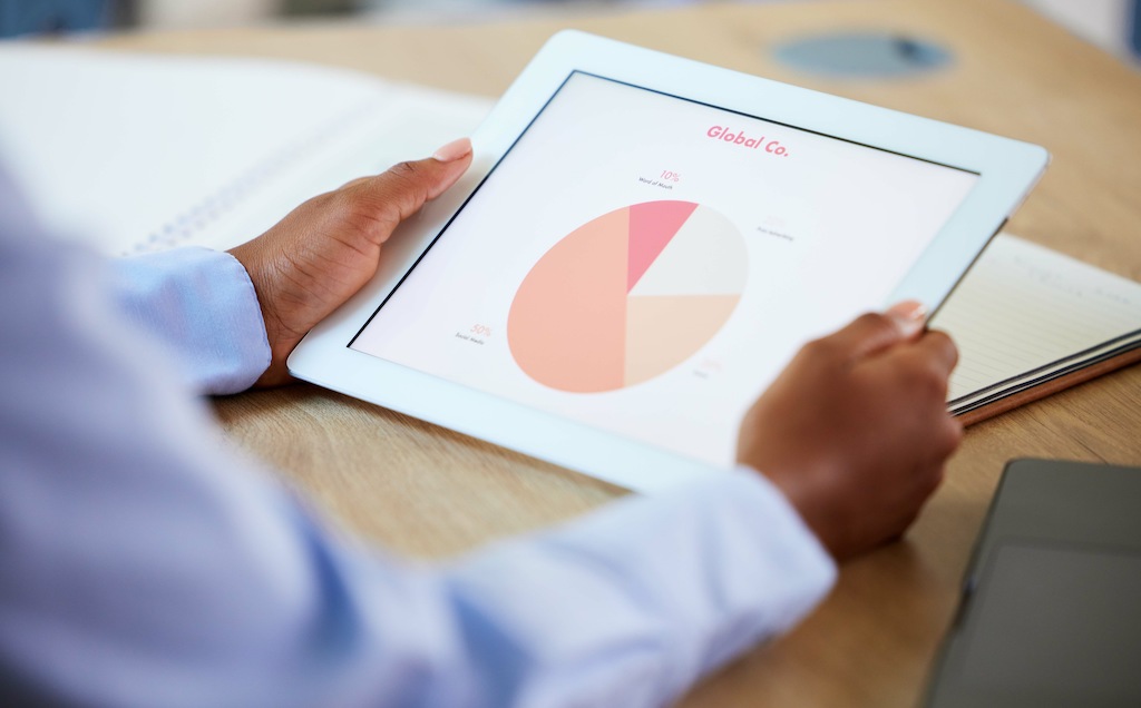 Defining your Marketing Goals Get Focused & Get Found eBook Chapter 6 Your Niche Market with male hands holding tablet with pie chart and data