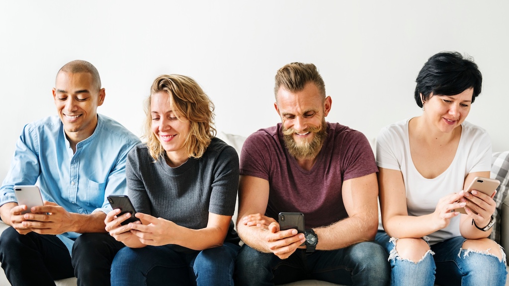 Group of different business owners reading and watching some entertaining content